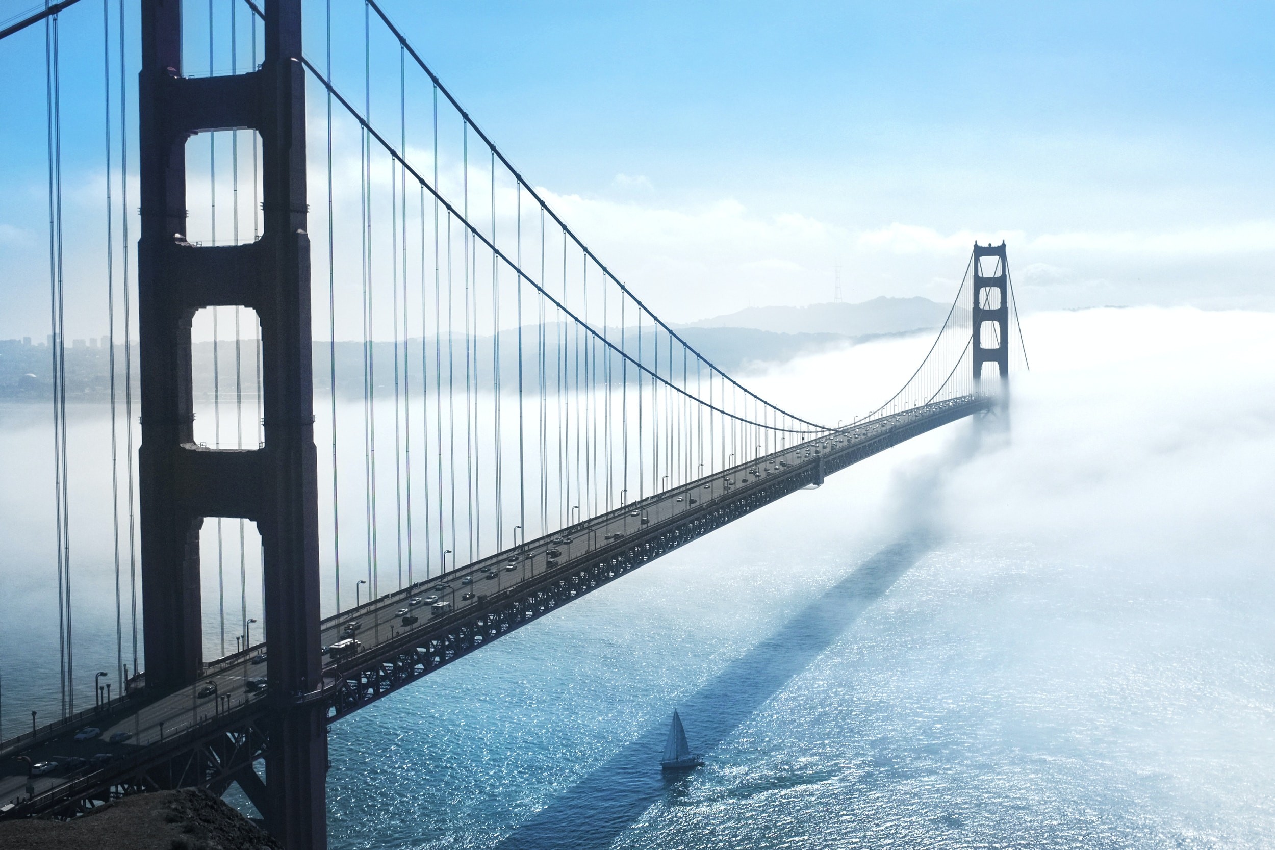Die Golden Gate Bridge im Nebel mit einem Segelboot unter der Brücke