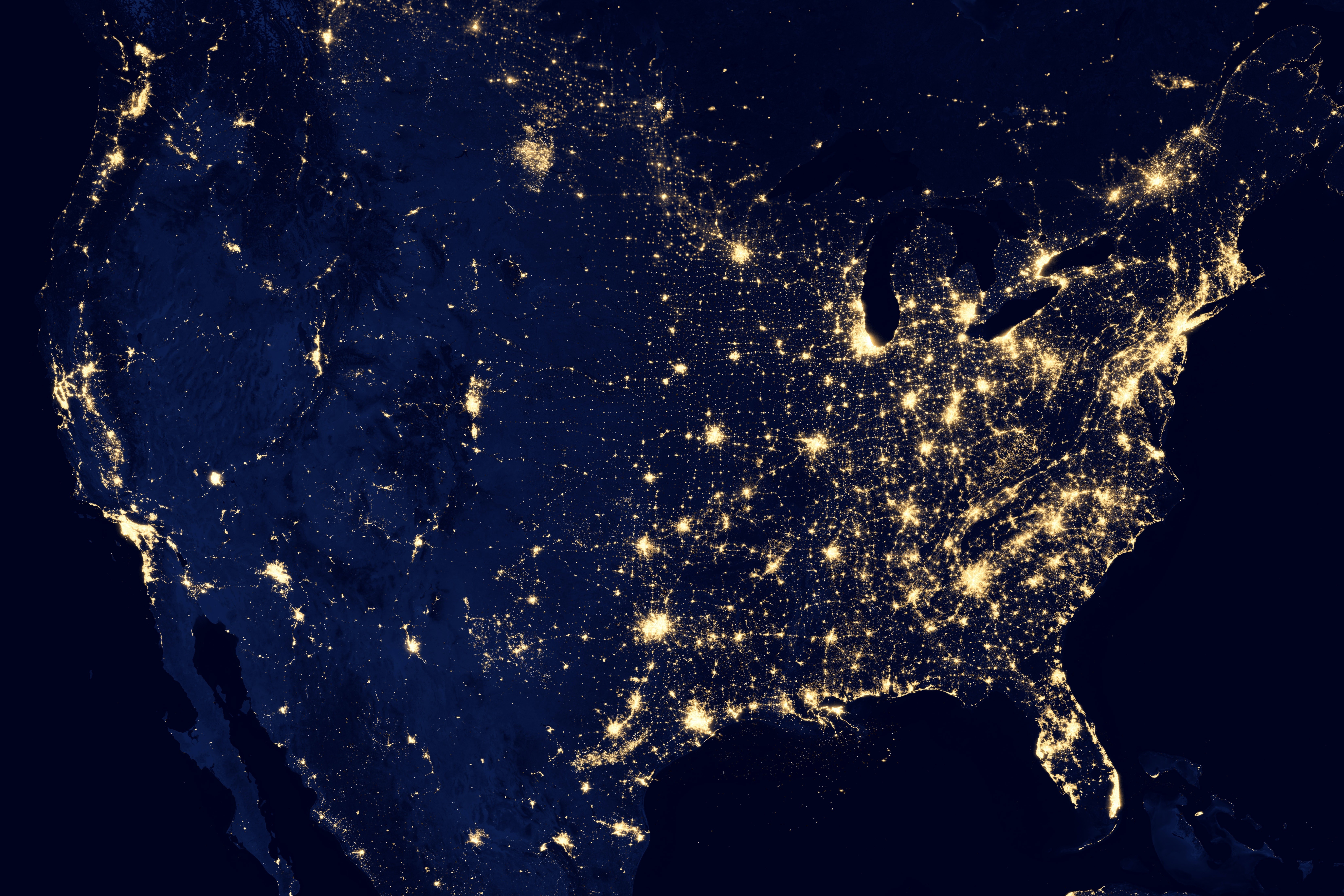 Ein Satellitenbild mit dem Blick auf Nordamerika in der Nacht, in der helle Lichter ein Netzwerk aus Verbindungen zwischen dicht besiedelten Gebieten darstellen