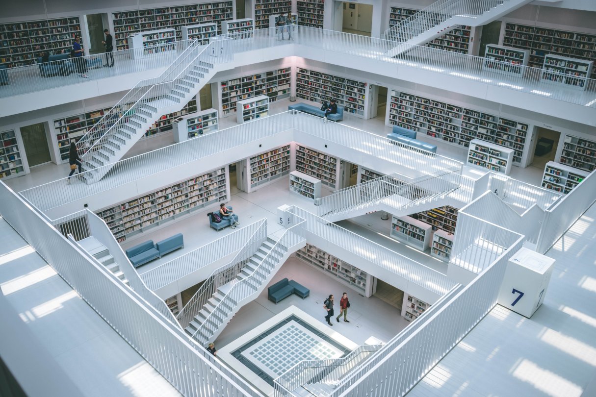Das Bild zeigt eine Fotografie von oben in eine große Bibliothek voller Bücher.