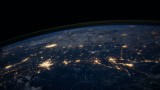 Satellitenaufnahme der Erde bei Nacht mit hell erleuchteten Städten