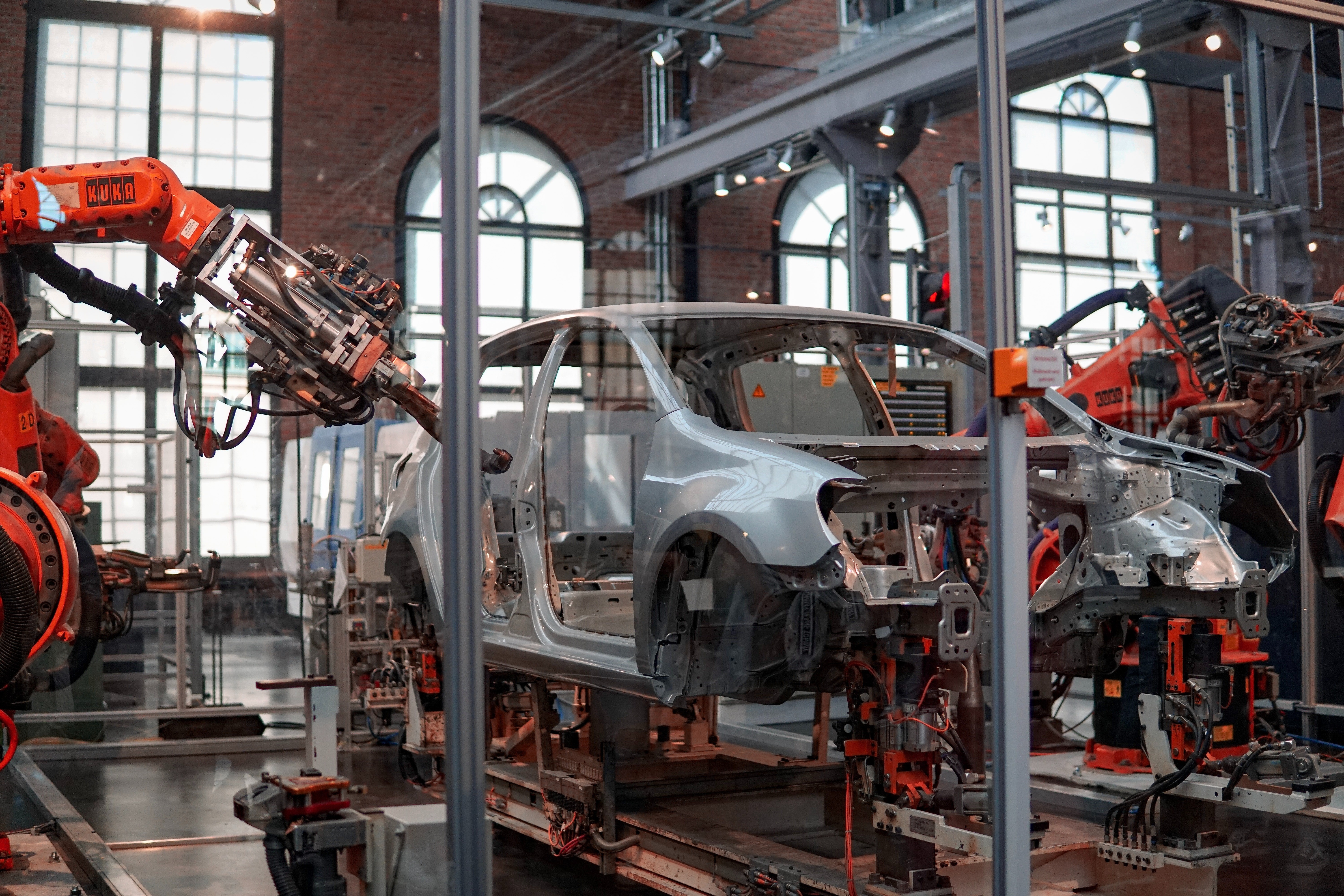 In einem Fabrikgebäude setzen Roboter ein Autogehäuse zusammen