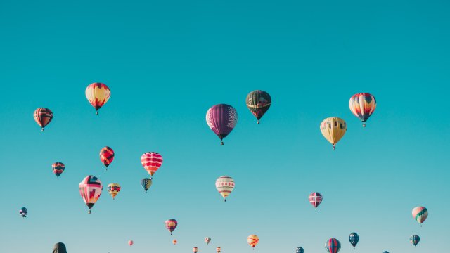Bunte Luftballons steigen in den blauen Himmel