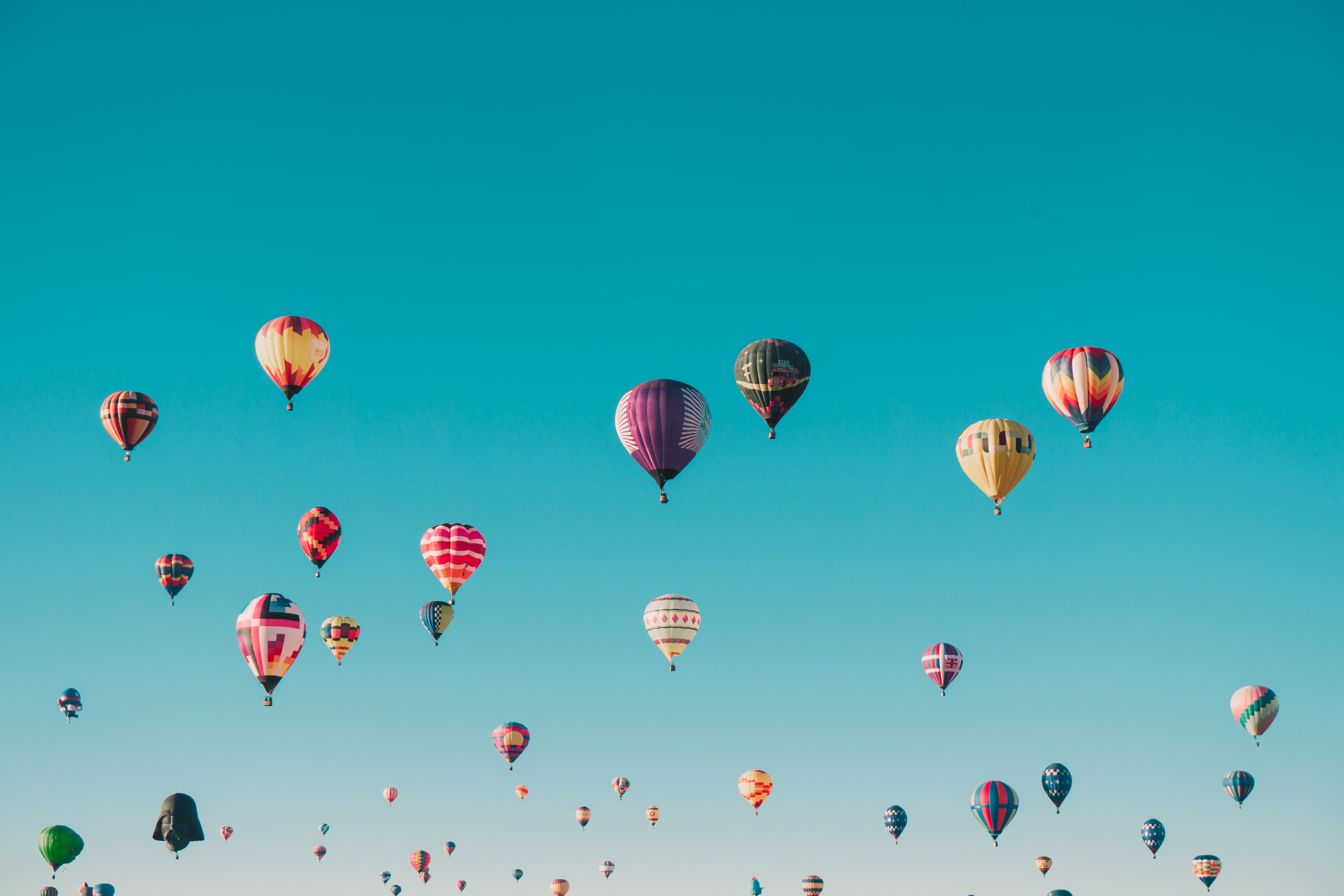 Bunte Luftballons steigen in den blauen Himmel