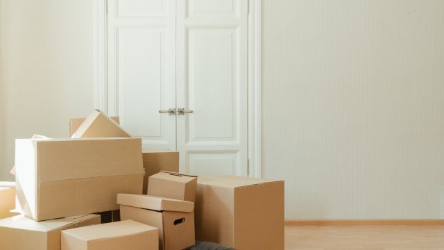 Mensch liegt unter Umzugskartons begraben