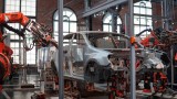 Das Bild zeigt die Herstellung einer Autokarosserie durch Roboter in einer Fabrik